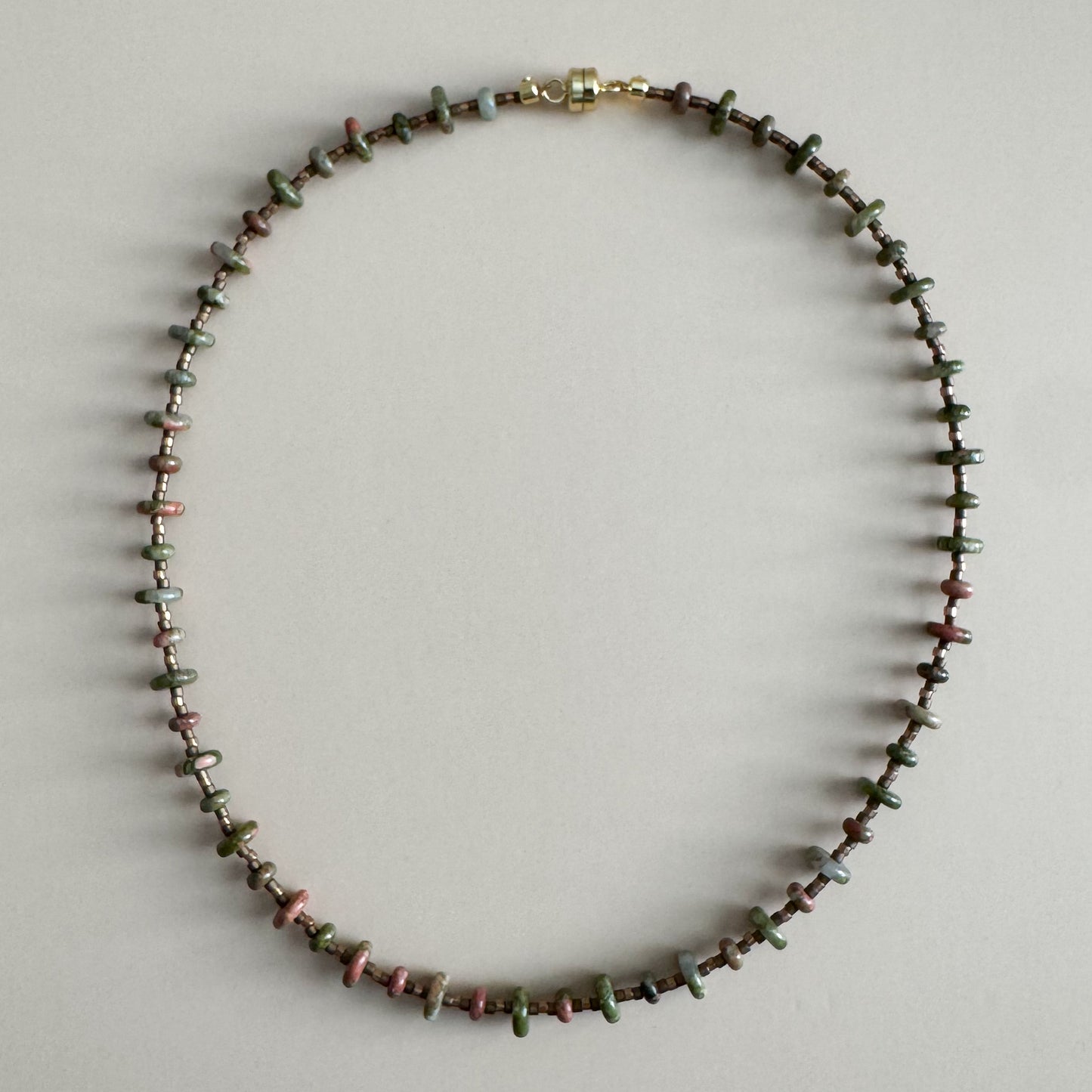 Necklace with small beads on a light gray background