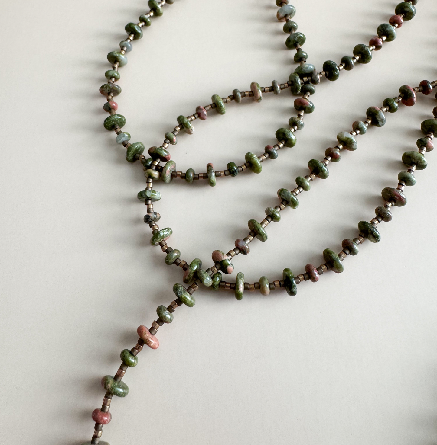 Beaded necklace with unakite 2mmx4mm beads on a light background
