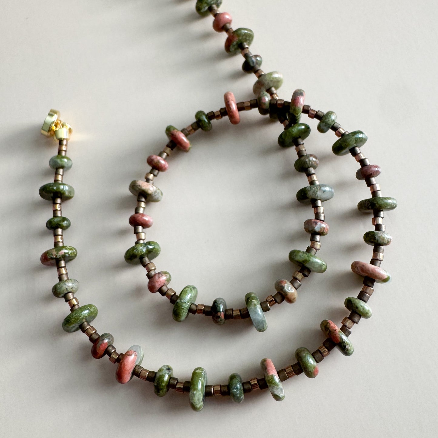 Necklace with unakite beads on a light gray background