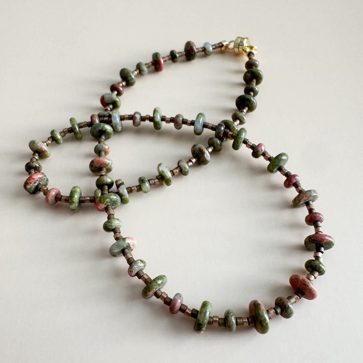 Beaded necklace with unakite 2mmx4mm beads on a light background