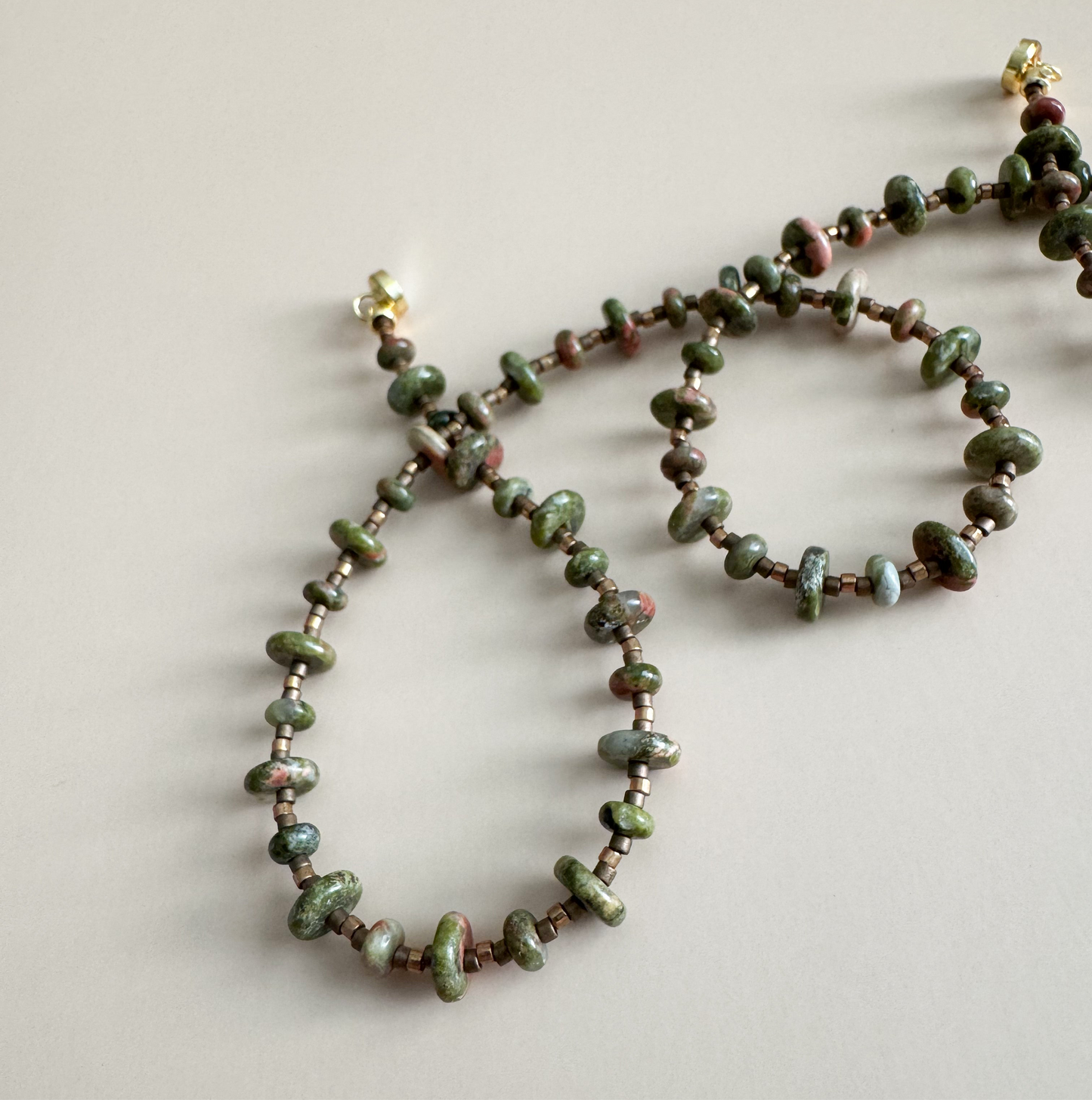 Beaded necklace with unakite 2mmx4mm beads on a light background