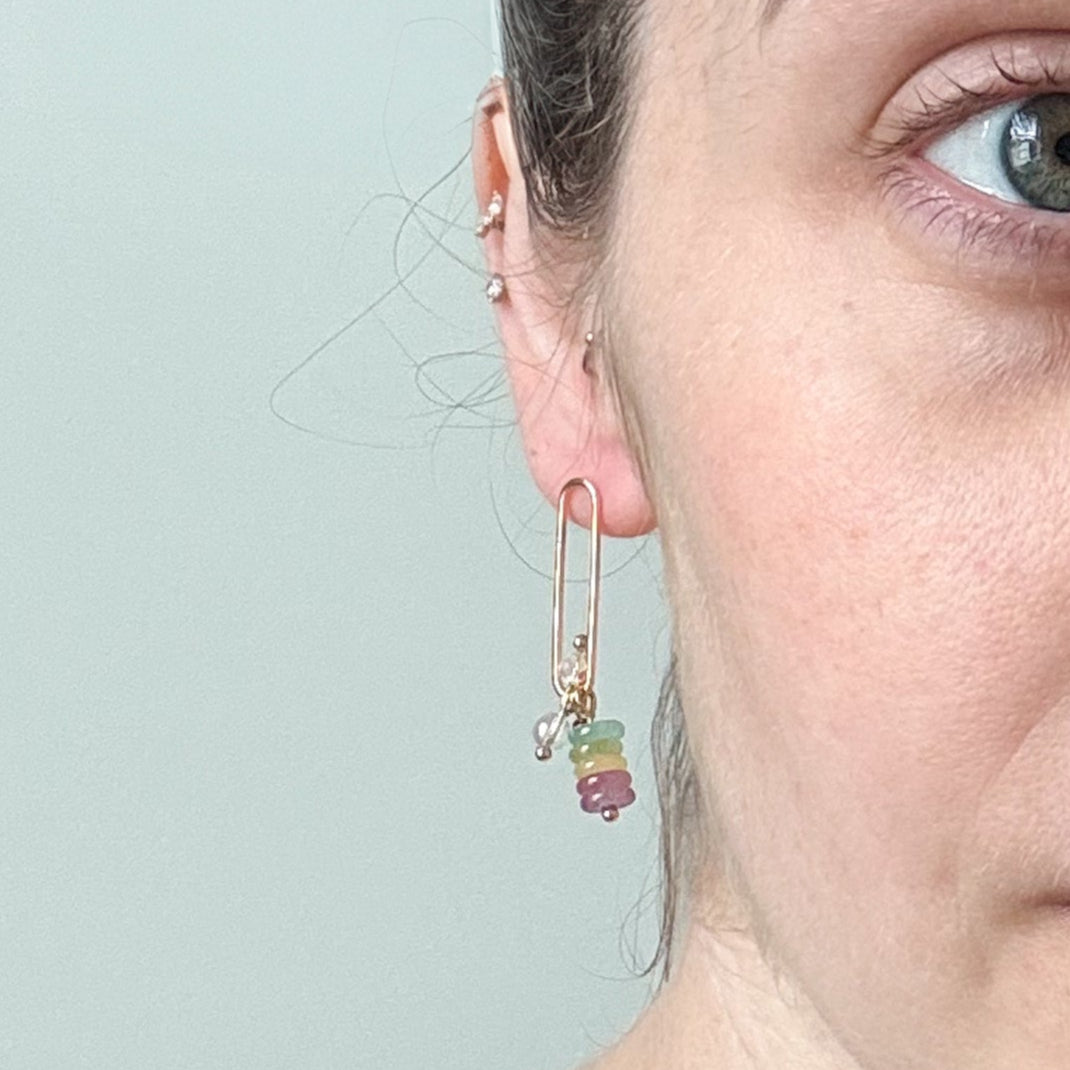 Close-up of a woman wearing earrings with a light gray background
