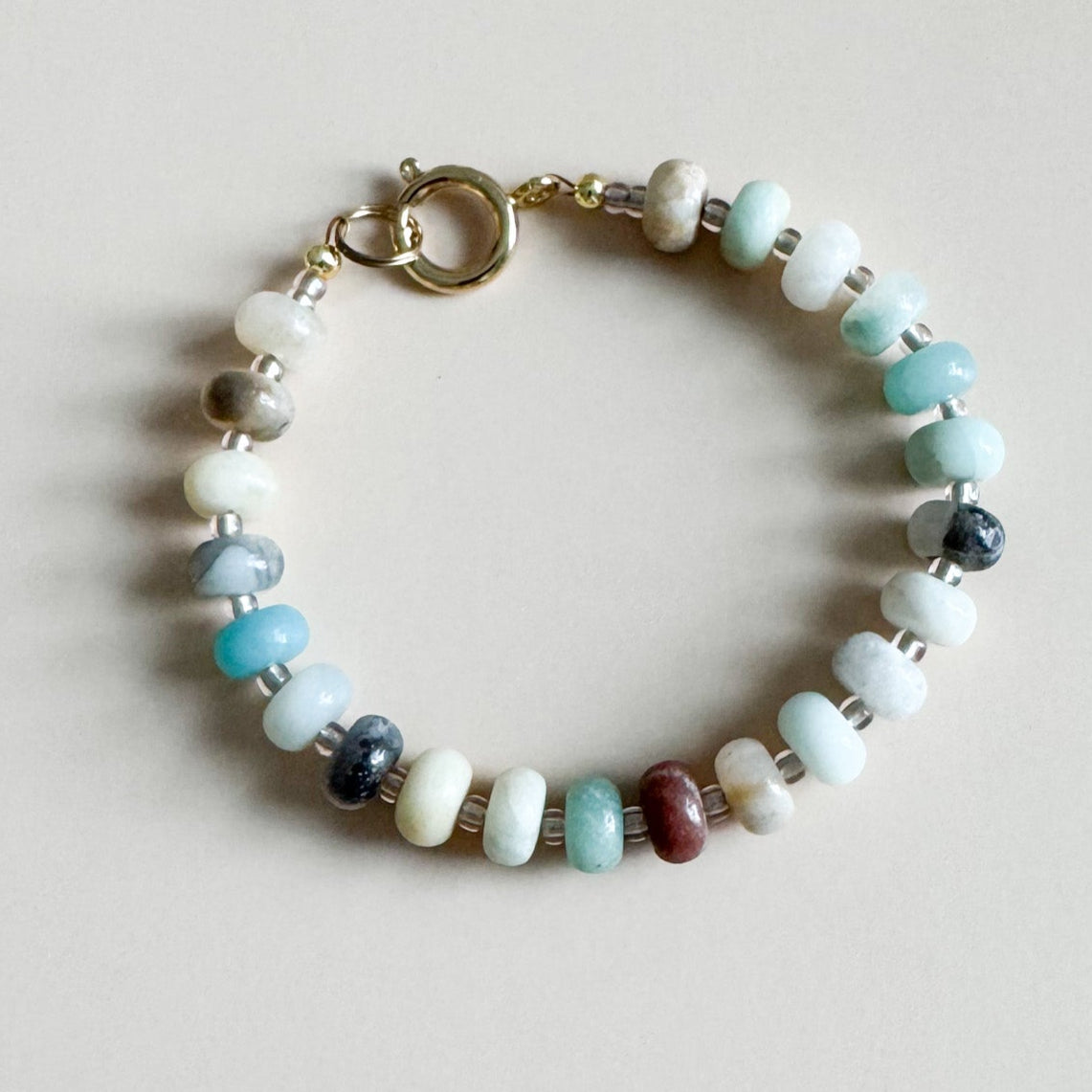 Beaded bracelet with multicolored beads on a light gray background