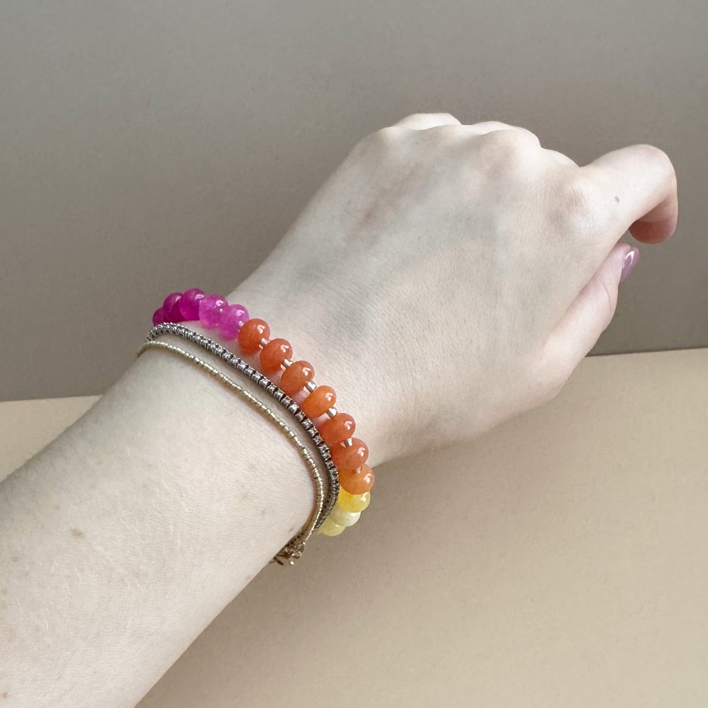Beaded bracelet with vibrant pink, orange, and yellow beads on a woman's wrist