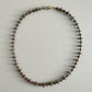 Necklace with small beads on a light gray background