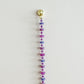 Beaded string with colorful beads and a gold clasp on a light gray background