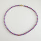 Multicolored beaded necklace on a light gray background