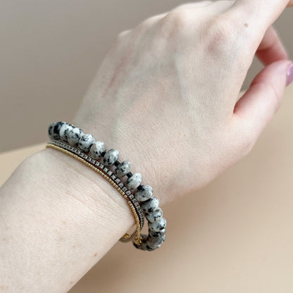 Hand wearing a bracelet with a neutral background