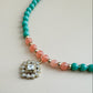 Mint green and translucent orange beaded bracelet with a decorative charm on a light background